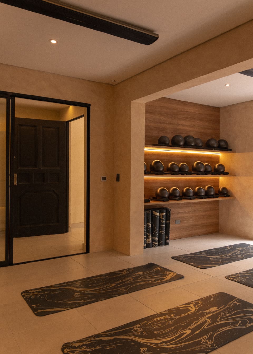 El salón movimiento libre de samaar: mats en el piso, muro de props de madera y puerta negra