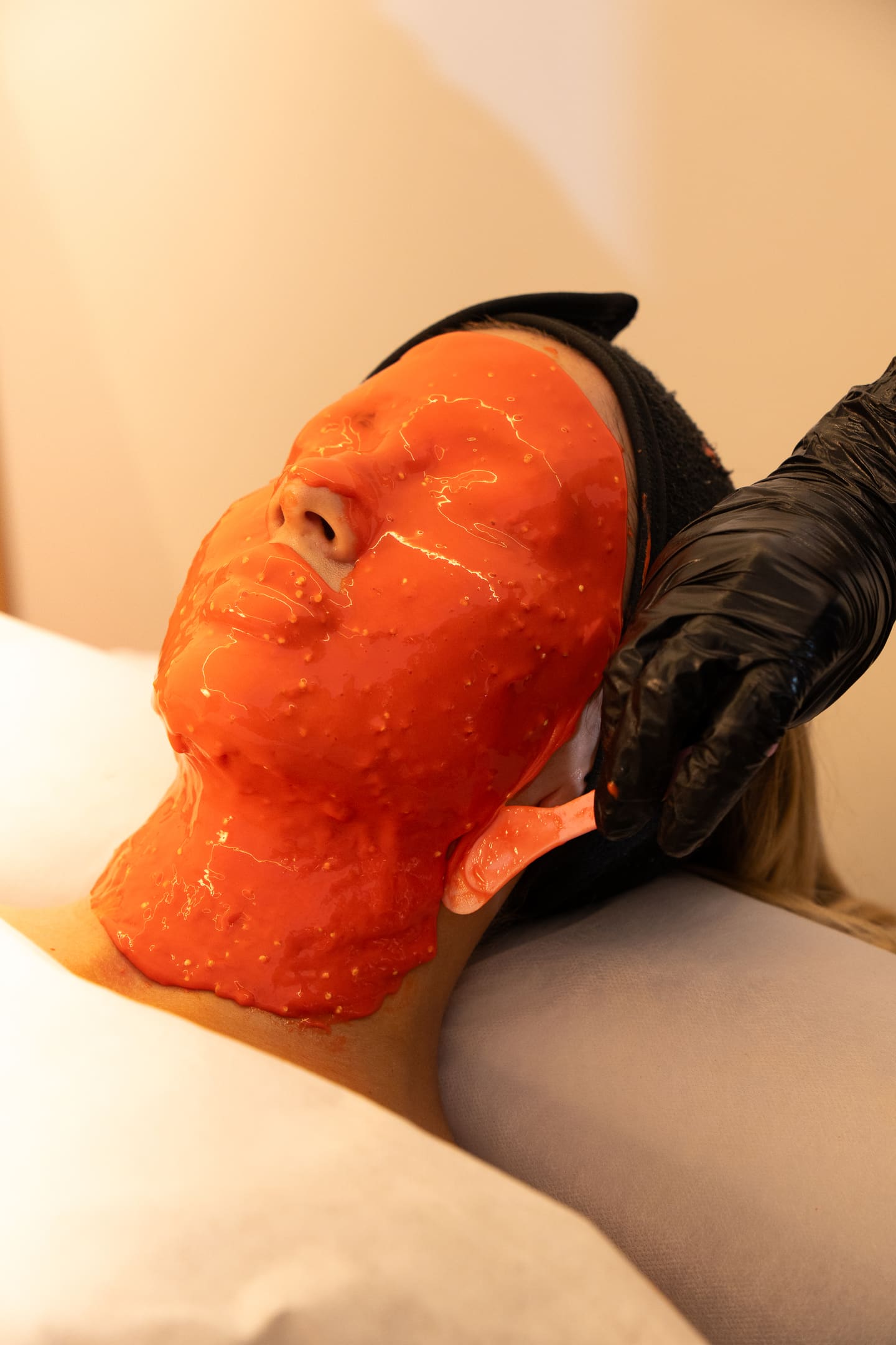 Aplicación de la mascarilla naranja del protocolo Casmara sobre el rostro de una clienta